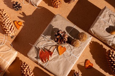 Noel 'i boşa harcamak, sert gölgelerle donatmak. El yapımı eko hediye, doğal yeni yıl jüt dekorasyonları üst manzara. Kraft kağıt ambalajı, plastik konsept olmadan. Portakal aromalı ağaçlar kalp çörekleri