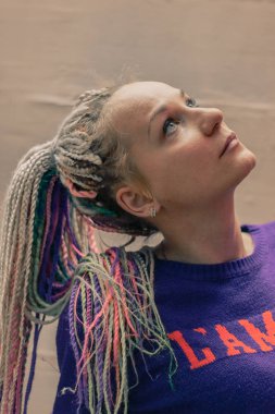 Afro tarzı küçük örgü şeklinde alışılmadık bir saç modeli ile sanatçının kız portre fotoğrafı