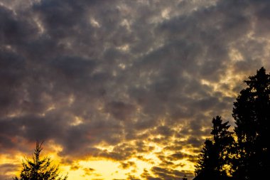 zengin mavi gökyüzü parlak gri beyaz kümülonimbus bulutlar ile kaplı ve akşam güneşin parlak ışınları ile aydınlatılmış durdurmak