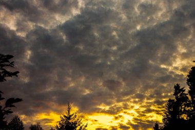 zengin mavi gökyüzü parlak gri beyaz kümülonimbus bulutlar ile kaplı ve akşam güneşin parlak ışınları ile aydınlatılmış durdurmak