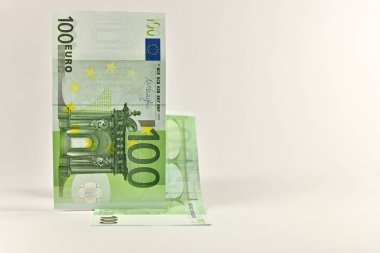 100 Euro. İki fatura kaldırdı. Dikey olarak çakışan. Işık arka planda kaldı. Ön ve arka taraf.