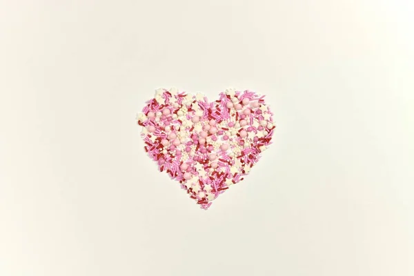 Růžové srdce z vymyšlené cukřenky na lehčím povrchu. Pohled shora. — Stock fotografie