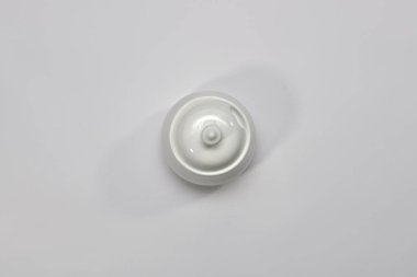 Beyaz porselen şeker kasesi ve hafif bir arka planı var. Üst görünüm, ortada..