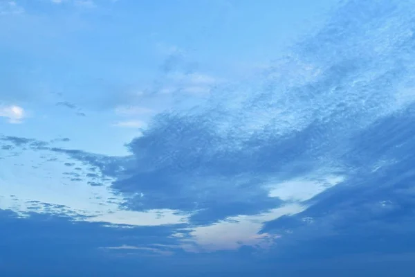 Nubes azules en un cielo azul ligeramente crepuscular. Abajo denso. Desde el centro se elevan hacia la esquina superior derecha del viento en la diagonal. Como pinceladas . — Foto de Stock