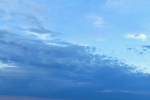 El firmamento se divide naturalmente en diagonal. En la esquina inferior izquierda de las densas nubes azules. La esquina superior derecha está ocupada por un cielo azul brillante con una pequeña cantidad de nubes de luz blanca . — Foto de Stock