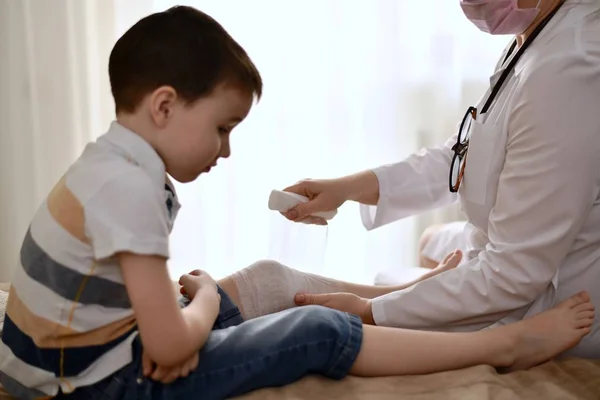 의사는 아이에게 의료 붕대를 둔다.. — 스톡 사진