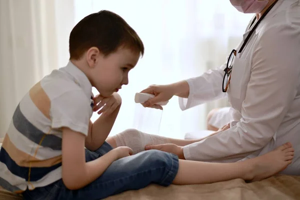 Üzgün bir çocuğa bandaj uygulamak. — Stok fotoğraf