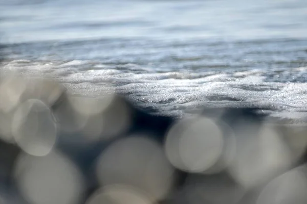 Zeekust bokeh en schuim op het oppervlak. — Stockfoto