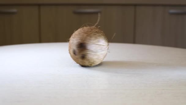 La filature de noix de coco est tout un tourbillon mûr autour de son axe sur la surface d'une table lumineuse dans la cuisine.