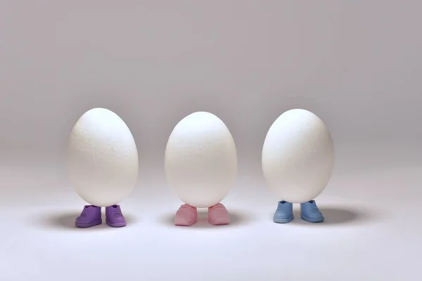 Три яйця загорнуті в різнокольорове взуття, стояти в центрі . — стокове фото