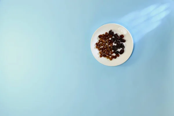 Солнечные Сухие Плоды Светлые Темные Белом Круглом Керамическом Блюдце Голубом — стоковое фото
