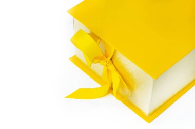 Sarı hediye, kurdeleli bir kutu, beyaz arka planda yay. Mutlu yıllar ya da mutlu Noeller. Boşluğu kopyala