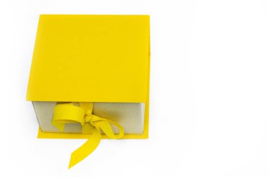 Sarı hediye, kurdeleli bir kutu, beyaz arka planda yay. Mutlu yıllar ya da mutlu Noeller. Uzayı kopyala Model.