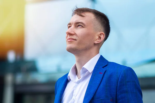 Profile portrait of handsome pensive thoughtful businessman, young positive guy in formal suit is dreaming outdoors, imagining, thinking about successful future, business or good career