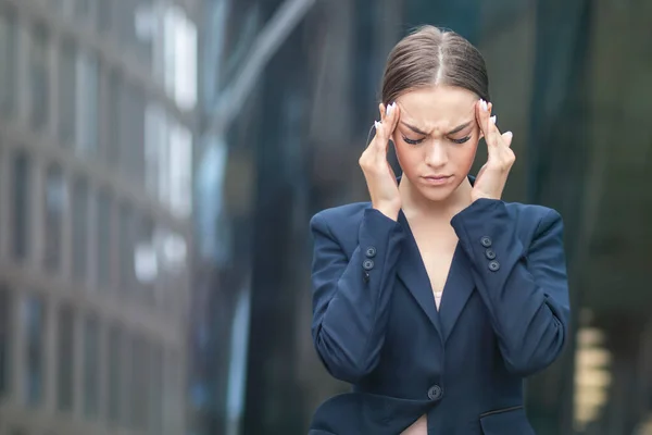 Exhausted tired frustrated businesswoman, beautiful young girl, lady looking at document, papers with sad negative look. Woman suffering from headache, migraine holding her head, temples with hand. — Stock Photo, Image