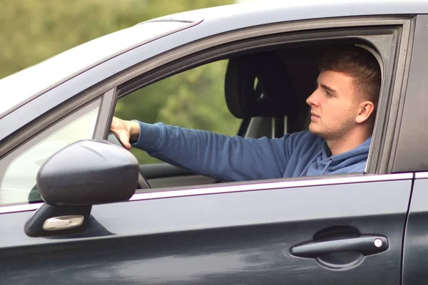 Jonge knappe man chauffeur rijdt in een auto — Stockfoto