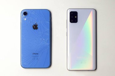 Saint-Petersburg, Rusya - 09.09.20: iki alet, bozuk, hasarlı ve yeni bir tane. iPhone XR ve Samsung. Takas konsepti, eski telefonu değiştirmek. Beyaz arkaplan