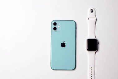 Saint-Petersburg, Rusya - 09.09.20: Apple 'ın yeni akıllı telefonu yeşil iPhone 11 ve Apple Watch' ı beyaz arkaplanlı akıllı saat