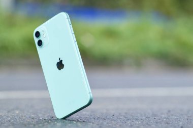 Saint-Petersburg, Rusya - 09.09.2020. Şok geçirmez iPhone 11 düşüyor, asfalta düşüyor, Apple akıllı telefonu yere düşüyor. Yok edilmiş, hasarlı telefon. Cihazla ilgili bir kaza. Çökme testi.