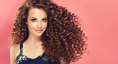 Beautiful model girl with long  curly hair . Care products ,hair coloring