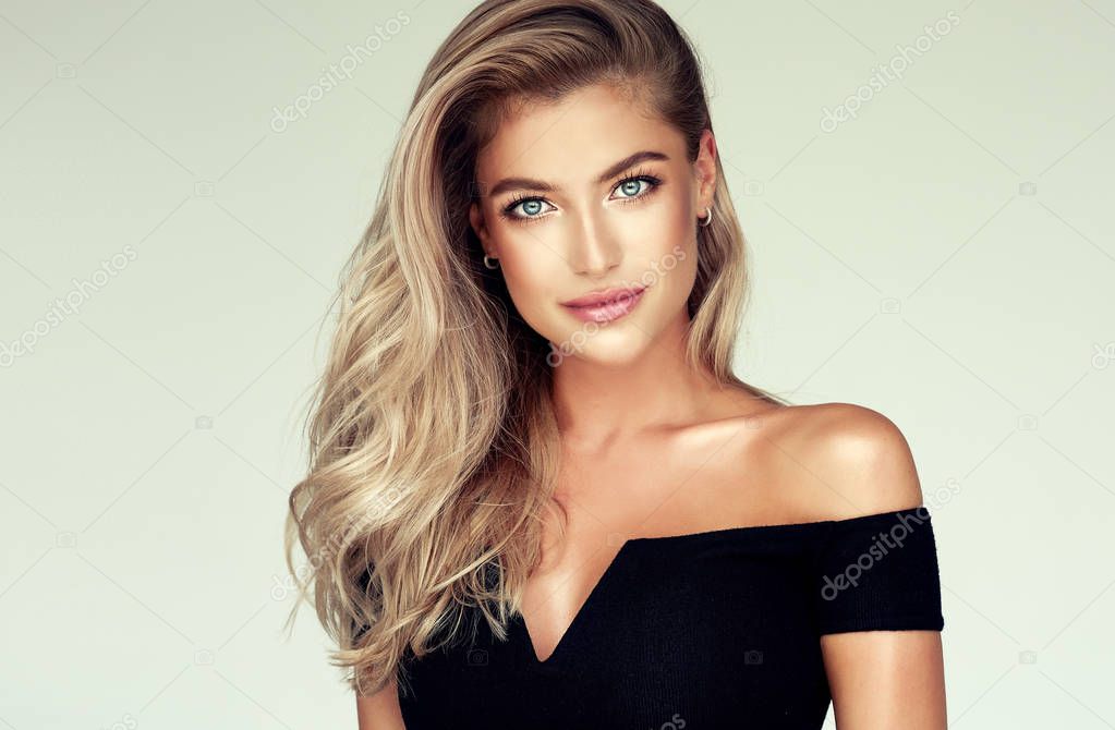 Young, blonde haired woman with   wavy hair .Beautiful model with long,  hairstyle .