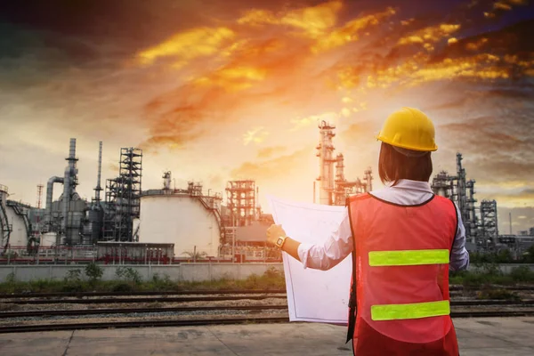 İnsanlar işçi kadınlar mühendisi petrol rafinerisi üretim Santrali enerji üretimi denetim çalışmalarında. Mühendislik onay bitki mavi günbatımı anda yazdırma.