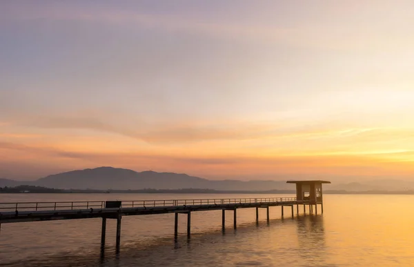 Puente de cemento, bomba de agua proyectándose hacia el río al atardecer . —  Fotos de Stock