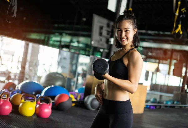 Sporty beautiful woman exercising with dumbbell weight training