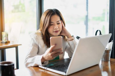 İş kadını kahvede bilgisayar ve akıllı telefon kullanıyor.