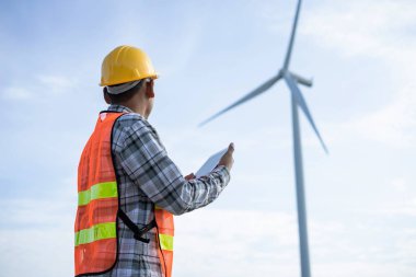 Rüzgar Değirmeni Güç Generindeki Erkek Mühendis tablet kontrol listesini tutuyor