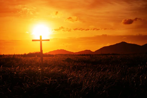 Cruz de madeira conceitual ou símbolo de religião sobre um céu pôr do sol com — Fotografia de Stock