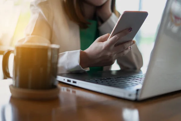 Geschäftsfrau arbeitet mit Computer und Smartphone im Kaffee — Stockfoto