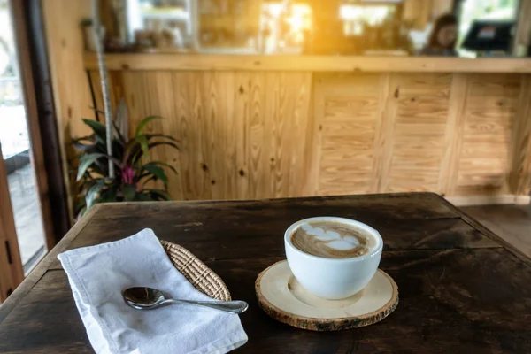 A fából készült asztal forró cappuccino kávéját a kerámia csésze — Stock Fotó