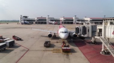 Don Mueang, Bangkok - January 24, 2020: Don Mueang International Airport-DMK. Footage B-roll Timelapse The plane of the Air Asia departs from the telescopic ladder.