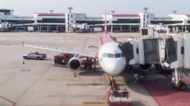 Don Mueang, Bangkok - January 24, 2020: Don Mueang International Airport-DMK. Footage B-roll Timelapse The plane of the Air Asia departs from the telescopic ladder.