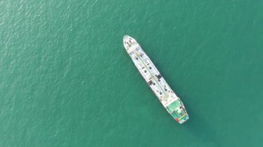 IPG ve petrol tankerini gemi lojistiği ile birlikte deniz limanında taşıyan geminin havadan görünüşü. Enerji ihracatı ve taşımacılık ticareti için. Görüntüler 4k B-roll sahnesi.