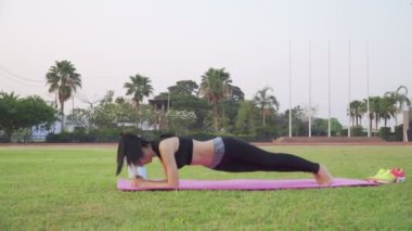 Asya 'lı Kadın' ın parkta esneme egzersizleri yapıp doğanın, temiz havanın ve fiziksel aktivitenin tadını çıkardığı görüntüler. Refah, eğlence ve gençlik kavramı. Kamera B-Roll Sahnesi 4k.