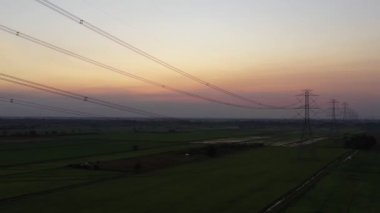 Aerial view drone shot. High voltage metal post. High-voltage towers in the forest with moving at sunset with twilight sky and clouds background. footage video b roll 4k.