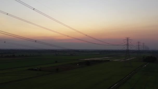 空中視ドローンが撃たれた 高電圧金属ポスト 夕暮れ時の空と雲の背景に移動すると 森の中の高電圧の塔 映像ビデオBロール4K — ストック動画