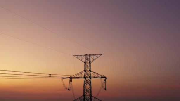 空中視ドローンが撃たれた 高電圧金属ポスト 夕暮れ時の空と雲の背景に移動すると 森の中の高電圧の塔 映像ビデオBロール4K — ストック動画