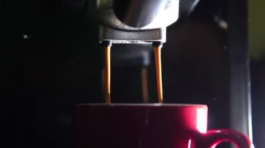 Kahve makinesinin fincanından dökülen kahvenin görüntüsü. Ev yapımı sıcak Espresso. Filtre tutacağı kullanılıyor. Taze kahve akıyor. Sabahları kavrulmuş sade kahve içmek.. 
