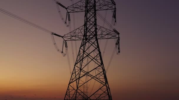 空中視ドローンが撃たれた 高電圧金属ポスト 夕暮れ時の空と雲の背景に移動すると 森の中の高電圧の塔 映像ビデオBロール4K — ストック動画