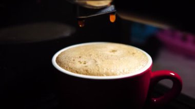 Kahve makinesinin fincanından dökülen kahvenin görüntüsü. Ev yapımı sıcak Espresso. Filtre tutacağı kullanılıyor. Taze kahve akıyor. Sabahları kavrulmuş sade kahve içmek.. 