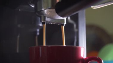 Kahve makinesinin fincanından dökülen kahvenin görüntüsü. Ev yapımı sıcak Espresso. Filtre tutacağı kullanılıyor. Taze kahve akıyor. Sabahları kavrulmuş sade kahve içmek.. 