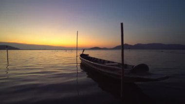 Footage B roll Scene of Sunset time at River with fishing boat and umbrella for relaxing. Beautiful nature and sunset twilight.