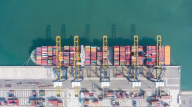 Crane 'in ithalat ticaret lojistiğinde yükleme konteynırları ile uluslararası limanın hiperlapse zaman ayarlı hava görüntüsü. Sanayi lojistik limanı. Endüstriyel limanda konteyner gemisi. Kamera B kaydı.