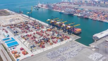 Crane 'in ithalat ticaret lojistiğinde yükleme konteynırları ile uluslararası limanın hiperlapse zaman ayarlı hava görüntüsü. Sanayi lojistik limanı. Endüstriyel limanda konteyner gemisi. Kamera B kaydı.