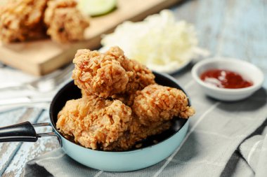 Bahçe masasında domates soslu kızarmış tavuk. Fast food sağlıksız.