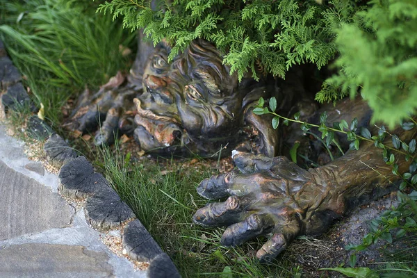 Escultura de jardín goblin bajo un arbusto — Foto de Stock