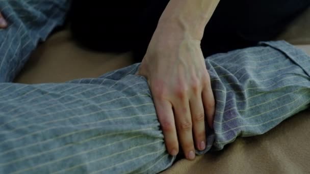 Maestro de masaje tailandés, realiza ejercicios de masaje y relajación de las piernas — Vídeo de stock